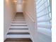 Elegant staircase with dark wood treads, white risers, and natural light from shuttered window at 803 Oak Bend Ln, Dunedin, FL 34698