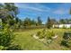 Lush backyard with green grass and a garden bed framed with white rocks, providing a peaceful retreat at 8423 Praise Dr, Tampa, FL 33625
