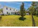 Large backyard featuring a screened lanai, expansive lawn, and mature trees for privacy and outdoor enjoyment at 8423 Praise Dr, Tampa, FL 33625
