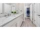 Bathroom features a double sink vanity with granite countertops and white cabinets, leading to a shower at 8423 Praise Dr, Tampa, FL 33625