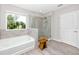 Bathroom featuring a soaking tub with tiled backsplash, a glass enclosed shower, and wood look flooring at 8423 Praise Dr, Tampa, FL 33625
