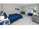 Comfortable bedroom with a blue quilted bedspread, grey carpet and built-in desk area with modern accessories at 8423 Praise Dr, Tampa, FL 33625