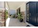Close-up of the front porch with stone pillars, seating, and a stylish dark blue front door at 8423 Praise Dr, Tampa, FL 33625