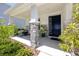Welcoming front porch featuring stone columns, seating, and a dark-colored front door at 8423 Praise Dr, Tampa, FL 33625