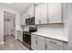 Kitchen features stainless steel stove and microwave, white backsplash, and gray cabinets at 8423 Praise Dr, Tampa, FL 33625