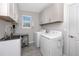 Well-organized laundry room with modern washer, dryer, sink, and storage cabinets for efficient chores at 8423 Praise Dr, Tampa, FL 33625