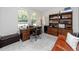 Office with wooden desk, bookcase, large window, and comfortable seating at 8423 Praise Dr, Tampa, FL 33625