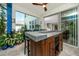 Screened-in outdoor kitchen features a built-in grill and bar, with easy access to the home's interior at 8423 Praise Dr, Tampa, FL 33625
