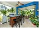 Screened-in outdoor kitchen features a built-in grill, a bar with seating, and views of the backyard at 8423 Praise Dr, Tampa, FL 33625