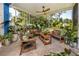 Relaxing screened patio with comfortable seating and lush tropical plants that bring the outdoors in at 8423 Praise Dr, Tampa, FL 33625