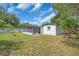 Backyard featuring a spacious lawn, an enclosed porch, and mature trees at 8501 56Th N St, Pinellas Park, FL 33781