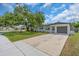 Charming single-story home featuring a well-manicured lawn and a long driveway leading to the attached garage at 8501 56Th N St, Pinellas Park, FL 33781