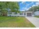 Charming single-story home with well-maintained lawn, a large shade tree, and an attached garage at 8501 56Th N St, Pinellas Park, FL 33781