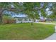 Well-maintained front yard featuring a mature oak tree and a charming bird bath at 8501 56Th N St, Pinellas Park, FL 33781