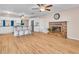 Open-concept living room and kitchen with wood floors, fireplace, and white cabinetry at 8501 56Th N St, Pinellas Park, FL 33781
