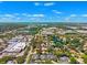 Expansive aerial view highlighting a residential neighborhood with lush trees, lakes, and commercial areas in the distance at 8645 Piper Ln, Seminole, FL 33777