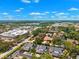 Beautiful aerial view showing a suburban neighborhood with mature trees, commercial areas, and a bright blue sky at 8645 Piper Ln, Seminole, FL 33777