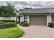 Well-maintained home exterior with a brick driveway, neutral paint, and manicured landscaping at 8645 Piper Ln, Seminole, FL 33777