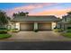 Charming home exterior features a symmetrical facade with two garages and updated landscaping at 8645 Piper Ln, Seminole, FL 33777