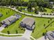 An aerial view showcases the property, pool, and lush landscaping in a desirable neighborhood near a scenic pond at 9508 Pyrenees Pl, Seffner, FL 33584