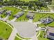 Aerial view of luxury neighborhood featuring manicured lawns, scenic pond, and spacious driveways at 9508 Pyrenees Pl, Seffner, FL 33584