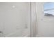 Bright bathroom features a white tiled shower and patterned curtain at 9508 Pyrenees Pl, Seffner, FL 33584