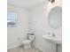 Stylish half bathroom featuring a white pedestal sink, and a toilet with tiled floor and a window at 9508 Pyrenees Pl, Seffner, FL 33584