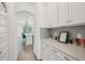 Hallway with white cabinets and granite countertops leading into the kitchen at 9508 Pyrenees Pl, Seffner, FL 33584