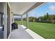 Covered patio with a barbecue overlooking the spacious lawn and fountain at 9508 Pyrenees Pl, Seffner, FL 33584