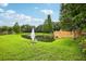 Scenic pond with fountain surrounded by lush green lawns and mature trees in a peaceful community setting at 9508 Pyrenees Pl, Seffner, FL 33584