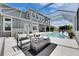 Inviting backyard with a cozy fire pit, stylish outdoor seating, and a screened-in pool area at 978 Signet Dr, Apollo Beach, FL 33572