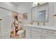 Bright, white bathroom featuring elegant gold fixtures, a shower/tub combo, and a modern vanity at 978 Signet Dr, Apollo Beach, FL 33572