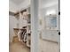 Organized walk-in closet and a peek into a modern bathroom with white marble floors at 978 Signet Dr, Apollo Beach, FL 33572