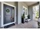 Inviting front porch with decorative wreath, modern seating, and stylish brick pavers at 978 Signet Dr, Apollo Beach, FL 33572