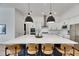 Stylish kitchen island featuring quartz countertops, pendant lighting, seating, and stainless appliances at 978 Signet Dr, Apollo Beach, FL 33572