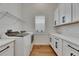 Clean laundry room with white cabinets, countertops, modern washer and dryer, and window at 978 Signet Dr, Apollo Beach, FL 33572