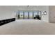 Large living room featuring neutral carpet, large windows with natural light, and modern light fixture at 978 Signet Dr, Apollo Beach, FL 33572