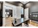 Modern office space with sleek desk, stylish decor, and a view into the dining area at 978 Signet Dr, Apollo Beach, FL 33572
