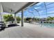 A covered outdoor pool area featuring lounge chairs, a dining table, and a serene, inviting atmosphere at 978 Signet Dr, Apollo Beach, FL 33572