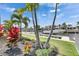 Picturesque waterfront view with lush landscaping, palm trees, and a private boat dock at 978 Signet Dr, Apollo Beach, FL 33572