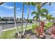 Waterfront home featuring a dock and landscaping with various palm trees at 978 Signet Dr, Apollo Beach, FL 33572