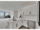 Wet bar with white cabinets, stainless beverage fridge and black hardware is an entertainer's dream! at 978 Signet Dr, Apollo Beach, FL 33572