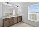 Bathroom featuring double sinks, a large mirror, and a window at 10115 Briar Cir, Hudson, FL 34667