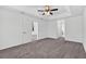 Bedroom features an open door leading to other rooms, a ceiling fan, and plush carpet at 10115 Briar Cir, Hudson, FL 34667