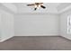 Spacious bedroom featuring a ceiling fan, plush carpet, and a window for natural light at 10115 Briar Cir, Hudson, FL 34667