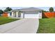 A concrete driveway leads to a two-car garage, complemented by a green lawn at 10115 Briar Cir, Hudson, FL 34667