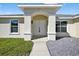 Welcoming front entrance featuring an arched doorway and modern lighting fixtures at 10115 Briar Cir, Hudson, FL 34667