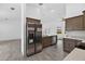Kitchen featuring stainless steel refrigerator, sink, and light wood cabinets at 10115 Briar Cir, Hudson, FL 34667