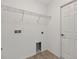 Inside a compact laundry room with tile floors, shelving, and hookups at 10115 Briar Cir, Hudson, FL 34667