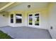 Covered patio featuring concrete flooring, exterior lighting, and peaceful backyard views at 10115 Briar Cir, Hudson, FL 34667